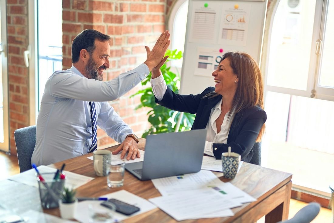 Investor and adviser celebrating a successful property deal during a meeting