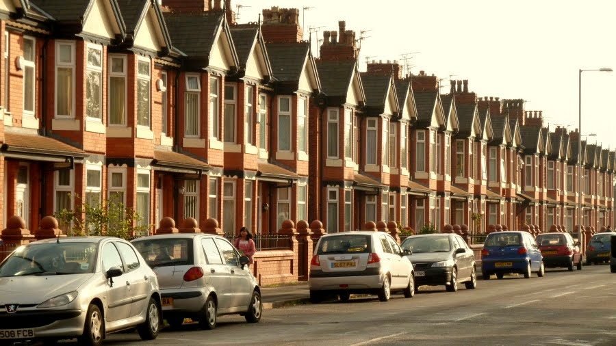 Red-brick Victorian terraced houses on a street in Manchester